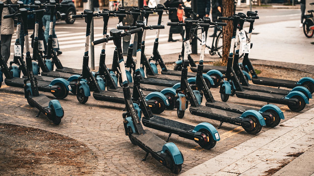 heros-img Multiple electric scooters parked on a cobblestone street in Florence, Italy, ready for use.